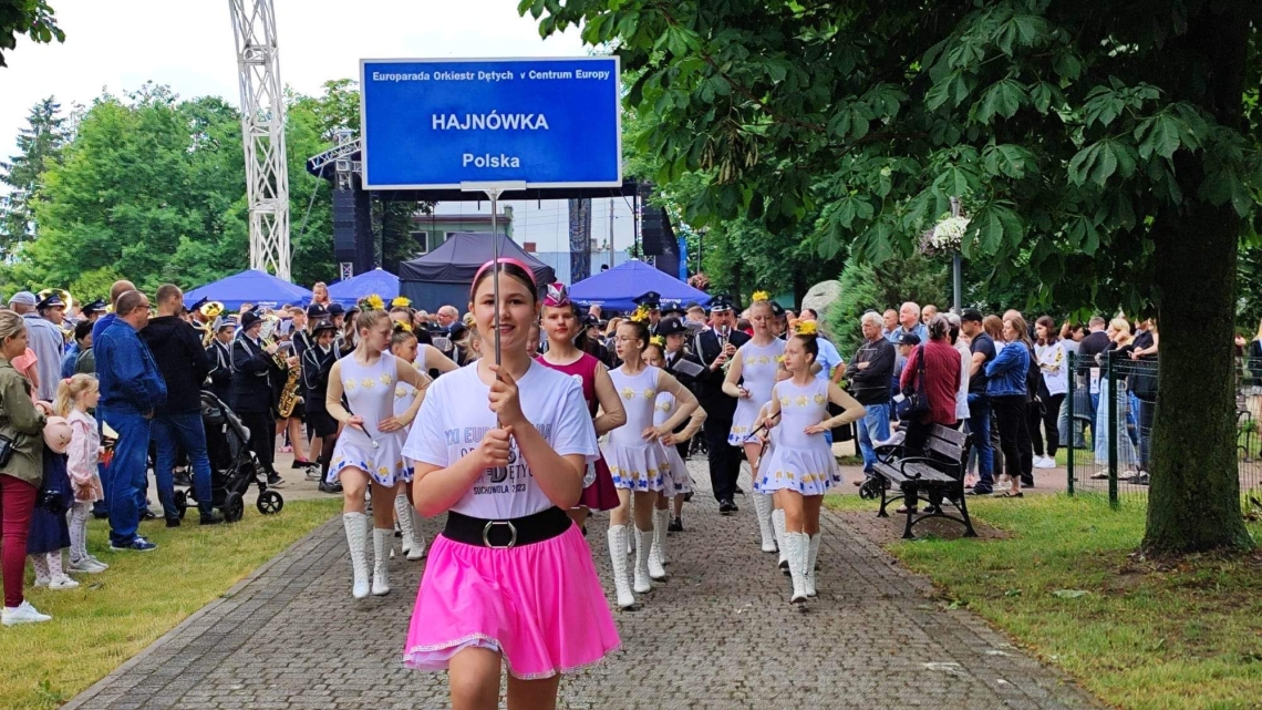 orkiestry dęte podczas parady, na czele orkiestra hajnowska z niebieską tabliczką z napisem Hajnówka