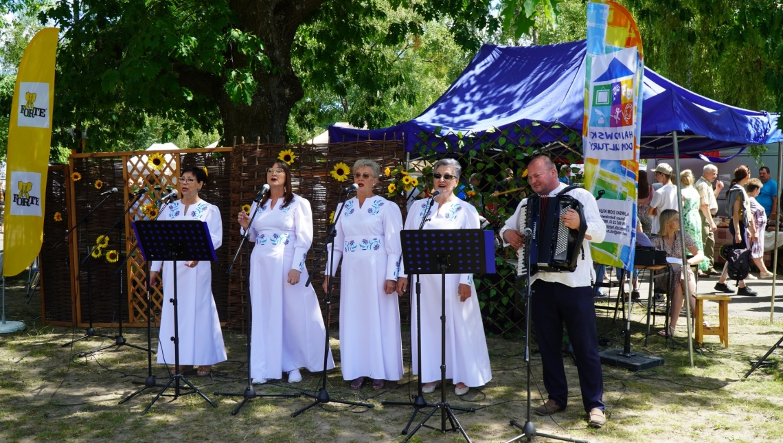 zespoł wokalny podczas występu w plenerze, cztery kobiety i mężczyzna z akordeonem