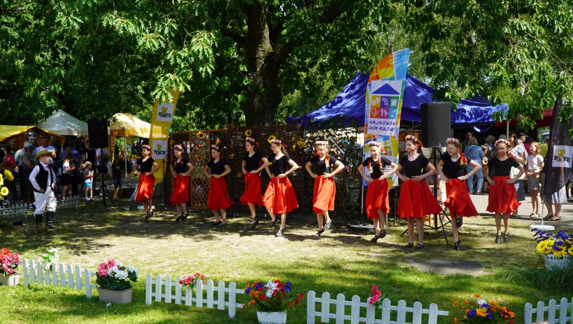 występ w plenerze zespołu dziewczęcego w czarno-czerwonych strojach