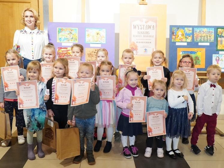 dzieci z dyplomami pozują do zdjecia z panią dyrektor domu kultury