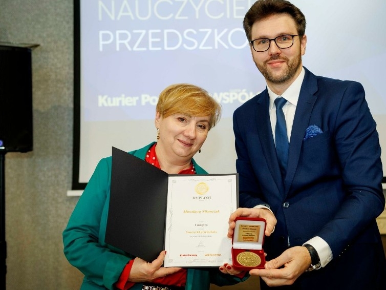 kobieta i meżczyzna trzymają odznaczenie