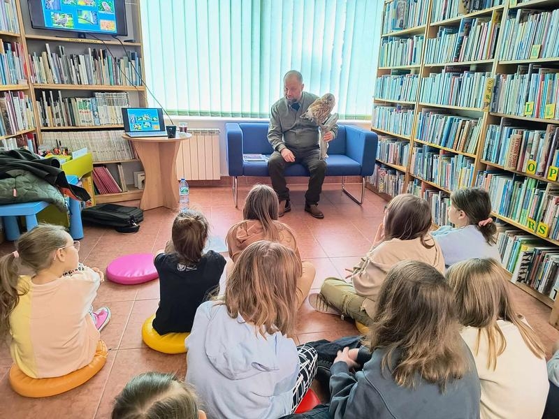 leśnik pokazuje dzieciom eksponat puszczyka