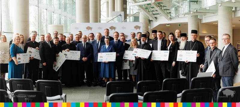 zdjecie pamiatkowe beneficjentów z czekami