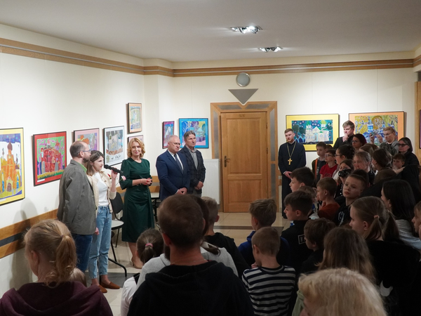 moment otwarcia wystawy. W tel widać zawieszone na ścianie prace plastyczne