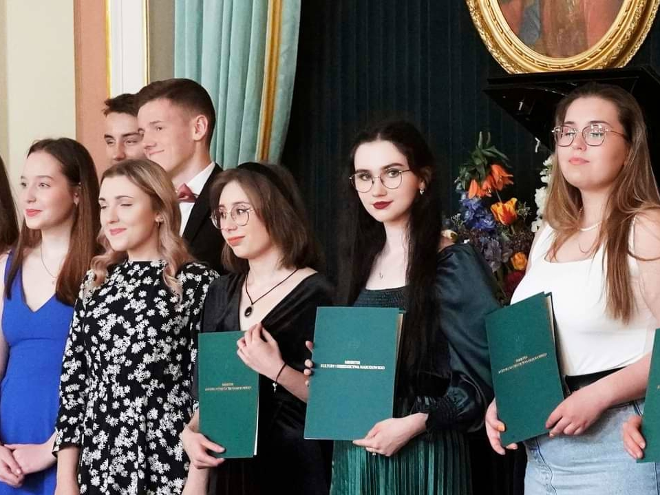 licealiści trzymają w dłoniach akta nadania stypendium