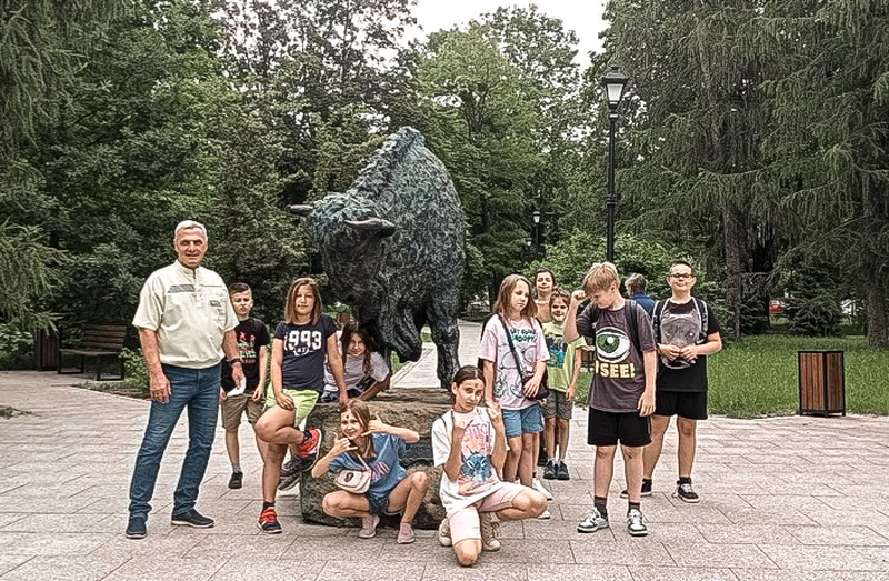 zdjecie pamiatkowe przy pomniku żubra w skwerku