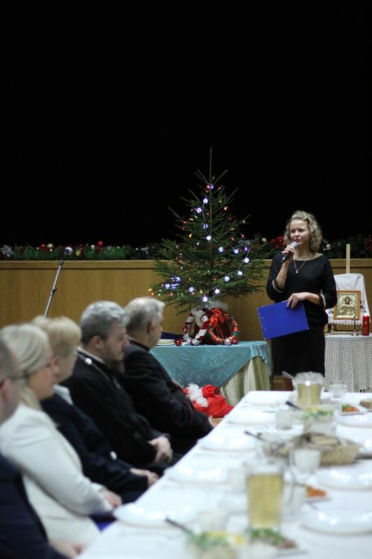 uczestnicy spotkania siedzą przy wigilijnym stole