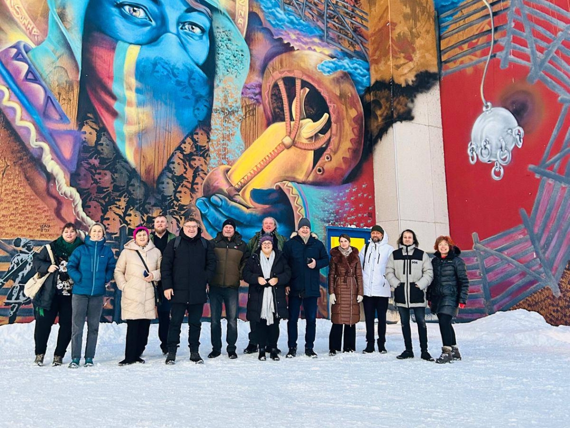 zdjęcie grupowe na tle kolorowego muralu na ścianie budynku