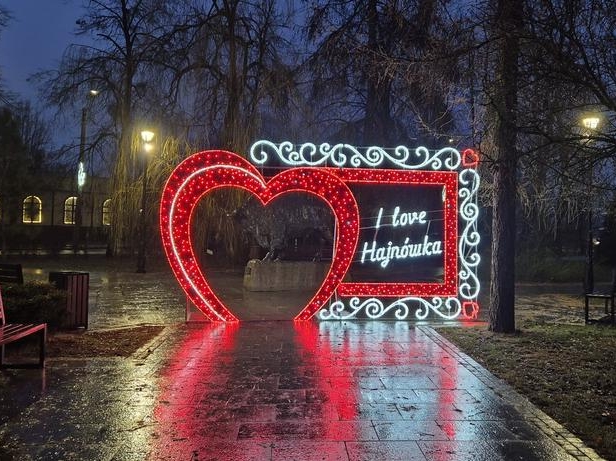 świecące serce z napisem LOVE HAJNÓWKA ustawione w skwerku miejskim