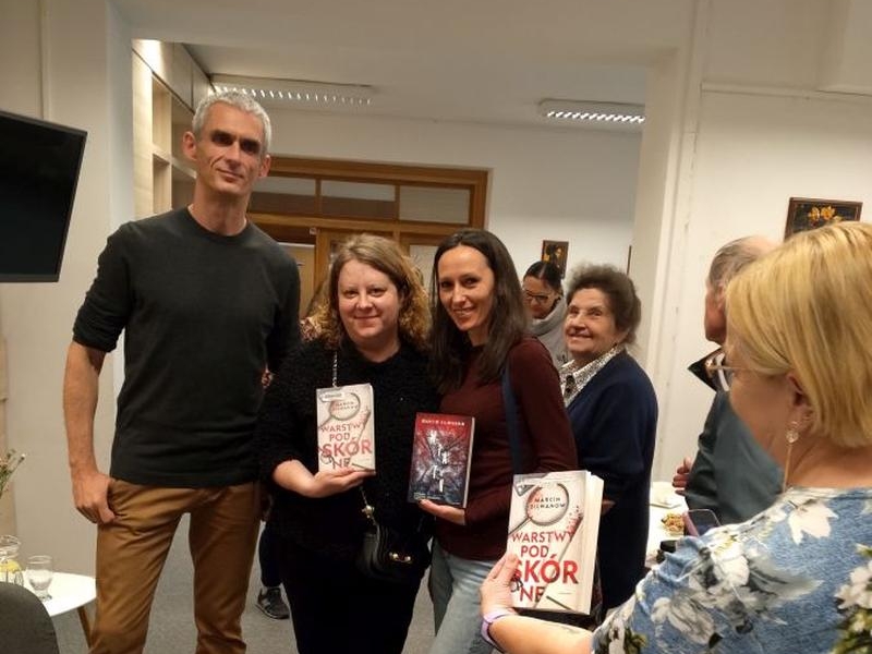  Marcin Silwanow pozuje do zdjęcia z paniami, które pokazują książki