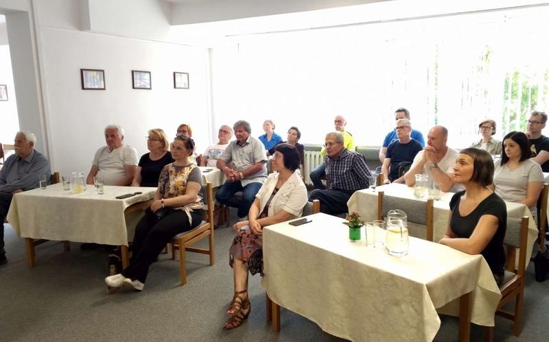 słuchacze na spotkaniu w sali bibliotecznej
