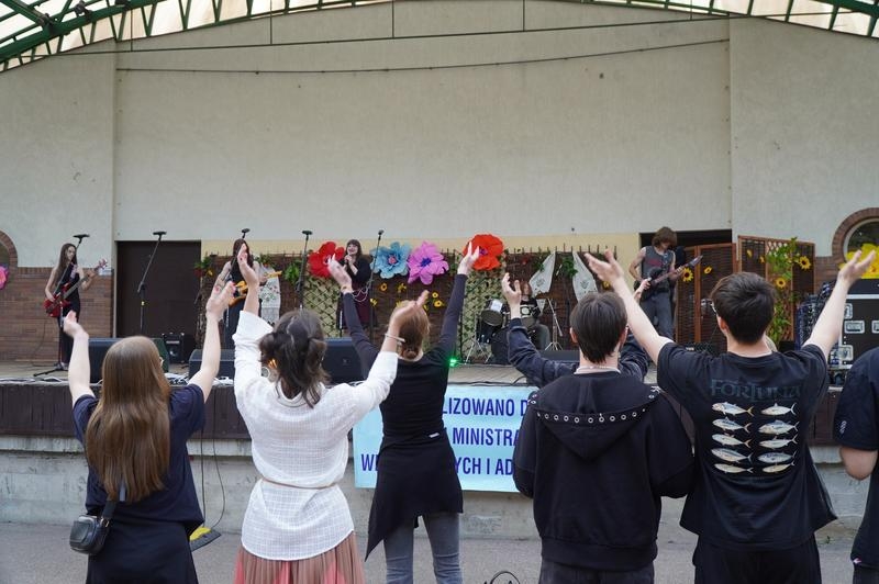 publiczność bawica się przed sceną, na której występuje zespół woklany