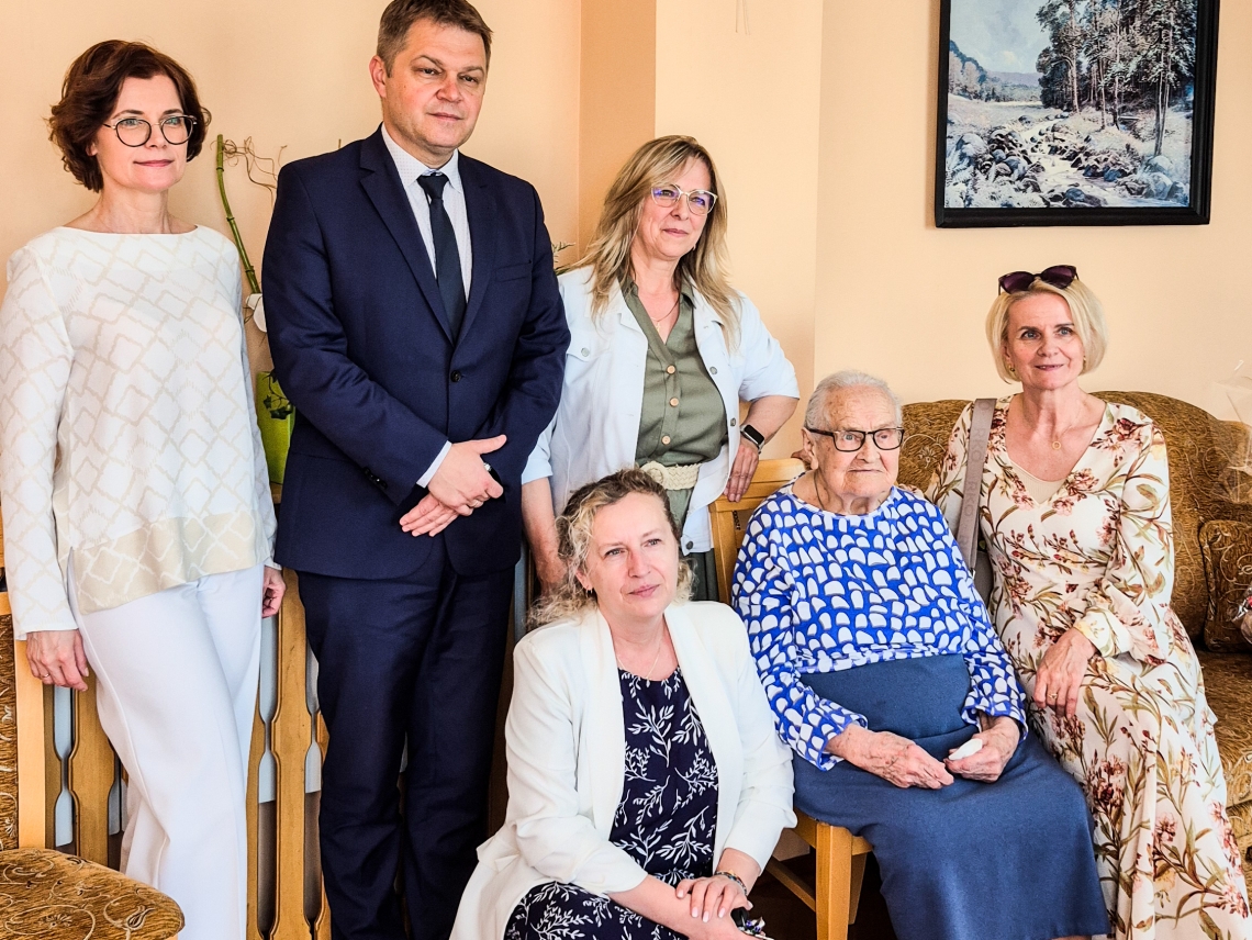zdjęcie 100latki z Burmistrzem, pracownikiem Urzędu Stanu Cywilnego oraz rodzina jubilatki