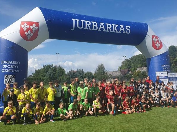 grupa młodych piłkarzy pod dmuchańcem z napisem:Jurbarkas