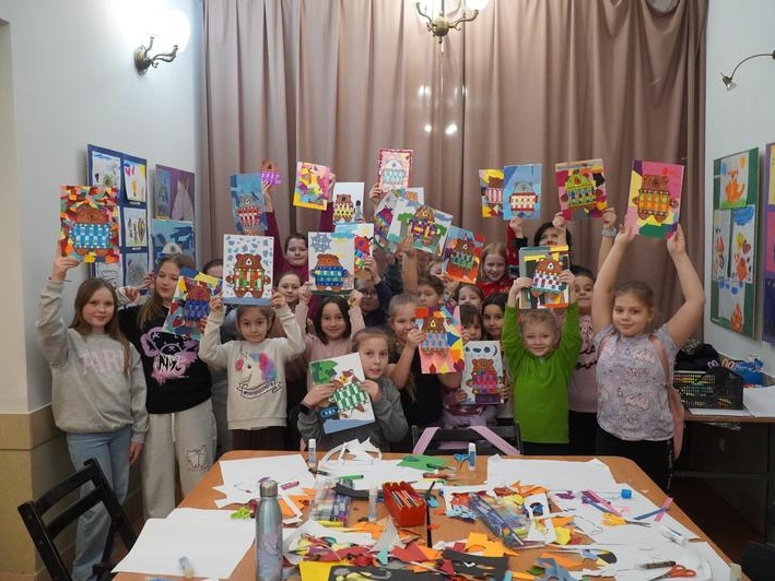 grupa dzieci prezentuje swoje prace plastyczne