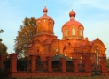 zdjęcie przedstawia dużą cerkiew, zbudowaną z czerwonej cegły; do góry wznoszą się dwie kopuły zwieńczone krzyżami