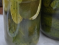 zdjęcie przedstawia szklane słoiki z zielonymi ogórkami kiszonymi