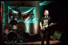 muzyk stojący przed mikrofonem, z gitarą w ręku