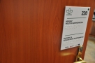 na drzwiach wejściowych do jednego z pokoi nad klamką umieszczona jest biała tabliczka z numerem pokoju, nazwa referatu, pod nimi znajdują się wypukłe napisy w alfabecie Breailla