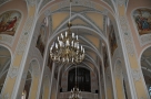wnętrze kościoła, zdjęcie ukazuje sklepienie z namalowanymi na ścianach obrazami oraz odobnikami; z sufitu zwisają żyrandole