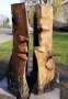 Na tle budynku HDK stoi rzeźba w drewnie, która przedstawia dwie strony ludzkiej głowy. Jedna z części stoi do góry nogami.