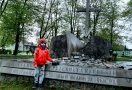 chłopczyk w czerwonej kurtce, stoi przy pomniku Ofiar Zbrodni i Przemocy, który znajduje się na skwerze im. Dymitra Wasilewskiego; chłopczyk w ręku trzyma miniaturowy czołg
