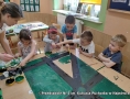 Dzieci malują makietę miasta.