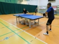 Dwóch meżczyzn gra w tenisa stołowego.