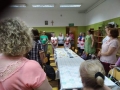 grupa uczestników ustwiona wokół kuchennego stołu