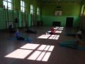grupa osób ćwicząca na matach z taśmami