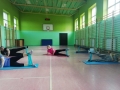 grupa osób ćwicząca na matach z taśmami