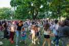 w parku miejskim wśród zieleni drzew duża grupa widzów - dzieci, dorośli z uśmiechami na twarzach