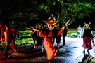 w nocnej scenerii alejkami parku spacerują przebrani aktorzy