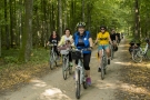 Zdjęcie uczestników rajdu jadą rowerami przez las
