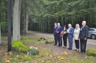 delagacja urzędów składająca kwiaty przy pomniku w lesie