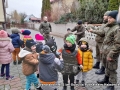 Zdjęcie dzieci i żołnieży, stoją na placu przed przedszkolem 