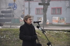 Alla Gryc ubrana w czarny płaszcz przemawia do mikrofonu