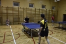 Mecz Hajnówka - Lombard Bielsk Podlaski, mężczyźni na sali gimnastycznej grają w tenisa stołowego.