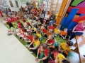 Dzieci siedzą na matach na sali gimnastycznej.
