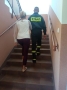 Kobieta i strażak wchodzą po schodach.