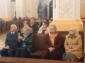 słuchacze koncertu siedzący w ławach kościoła