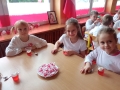 Dzieci jedzą biało - czerwone galaretki.
