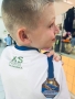 Chłopiec w koszulce KS Puszcza demontruje medal