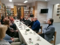 uczestnicy spotkania w bibilotece usadzeni za stołem