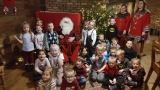 Dzieci pozują do zdjęcia ze Świętym Mikołajek