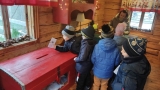 Dzieci wrzucają lusty do czerwonej skrzyni