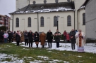 delegacje samorządowe podczas śpiewania hymnu. W tle widać kościół.