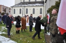 Burmistrz składa wieniec przy pomniku. W lewej strony stoją delegacje samorzadów hajnowskich. Z prawej strony stoi żołnierz na warcie.