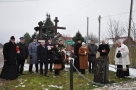 delegacje samorządowe i duchowni w Orzeszkowie. W tle widać zabudowania i krzyż.