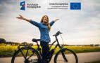 kobieta przy rowerze oraz loga unijne